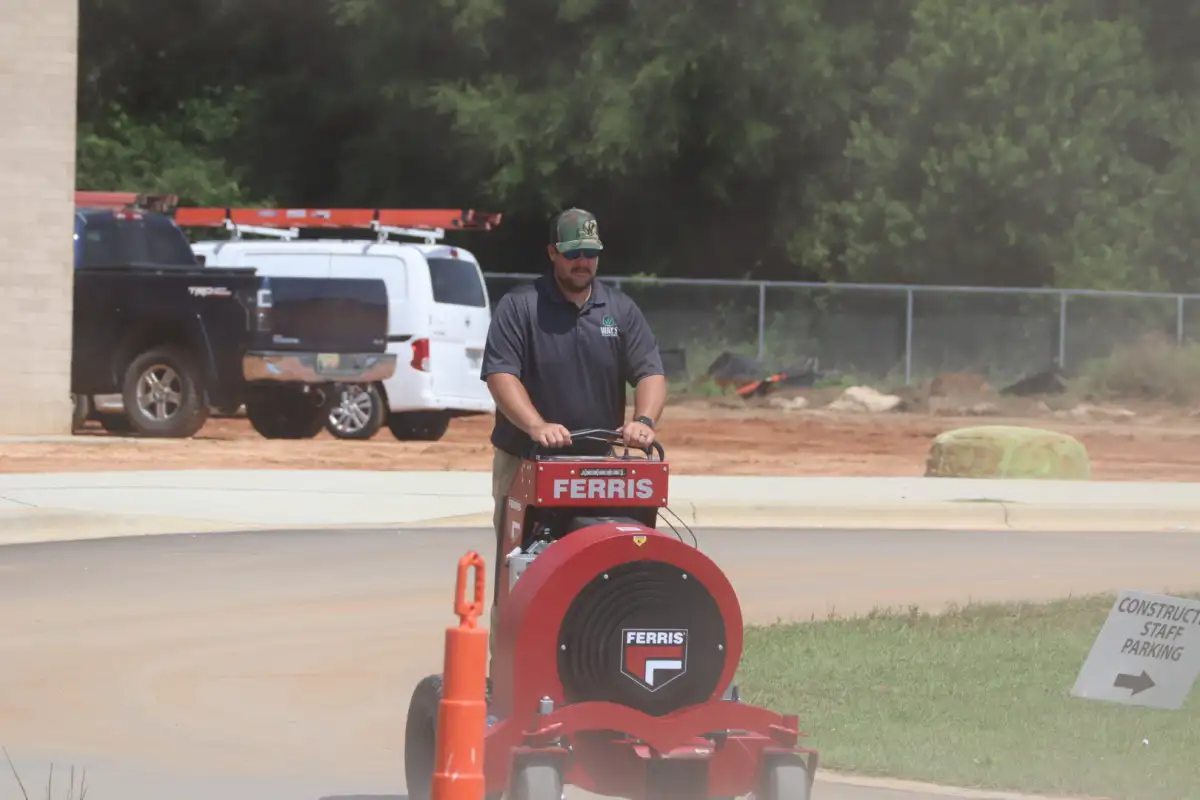 Way's Lawn and Landscape team member operating grounds-care equipment on a job site